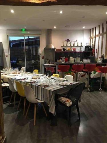 une salle à manger avec une longue table et des chaises dans l'établissement Villa des 3 cœurs, à Saint-André-les-Vergers