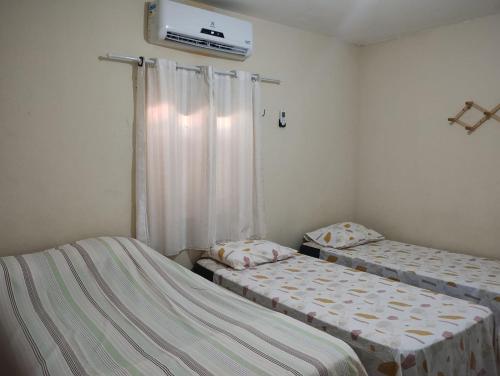 ジョアンペソアにあるCASA À 3 KM PRAIA TAMBAÚのベッドが2つと壁にテレビがある部屋