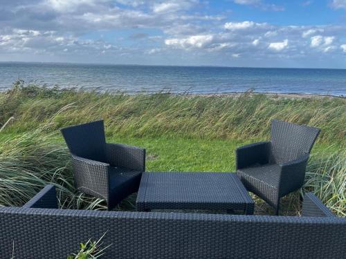 two chairs and a table on the beach at Augustenhof Ferien in Nordborg