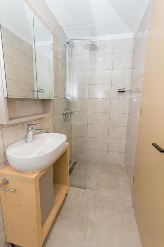 a bathroom with a sink and a shower at House of Nileides in Gargaliánoi