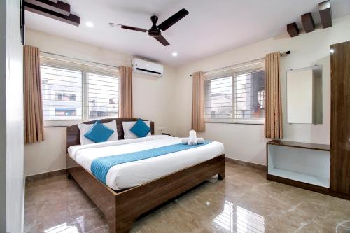 a bedroom with a bed and a ceiling fan at beestay Hotels Visakhapatnam in Visakhapatnam