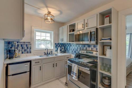 a kitchen with white cabinets and blue tiles on the walls at Bohemian Retreat Sleeps 6, two miles from Broadway! in Nashville