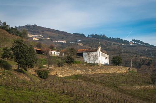 a small white church on a hill in a field at Quinta dos Poeiros in Medrões