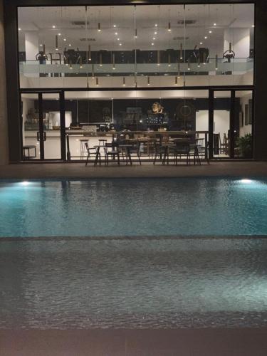 a swimming pool in a building with a table and chairs at Accra Luxury Apartments at Embassy Gardens in Accra