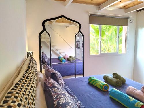 a room with a bed and a mirror at Oasis Tamarindo 1 - Casa Rosa - Appartement 2 chambres climatisées in Corralejo