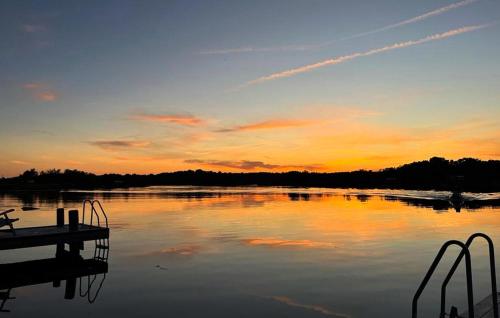 a sunset over a large lake with a dock at Nice Home In Ronneby With Wifi in Ronneby