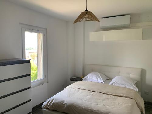une chambre blanche avec un lit et une fenêtre dans l'établissement Appartement Cagnes sur mer, à Villeneuve-Loubet