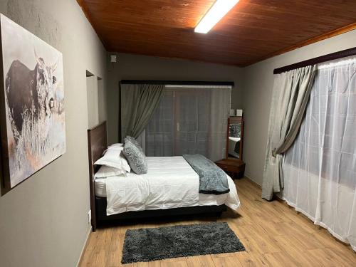 a bedroom with a bed and a large window at 72 on Devenish in Polokwane