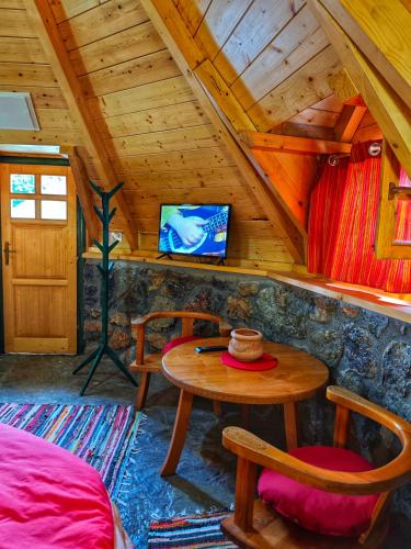 a room with a table and a tv in a cabin at KOZAK Apartments & Restaurant in Mojkovac