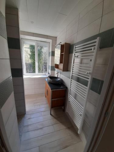 une petite salle de bain avec un lavabo et une fenêtre dans l'établissement Gîte calme bercé par le bruit du ruisseau, à Arinthod