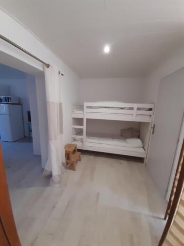 - une chambre avec des lits superposés blancs dans l'établissement Gîte calme bercé par le bruit du ruisseau, à Arinthod