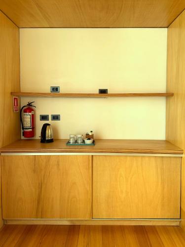 a kitchen with wooden cabinets and a shelf at CABITO B & B in La Paloma