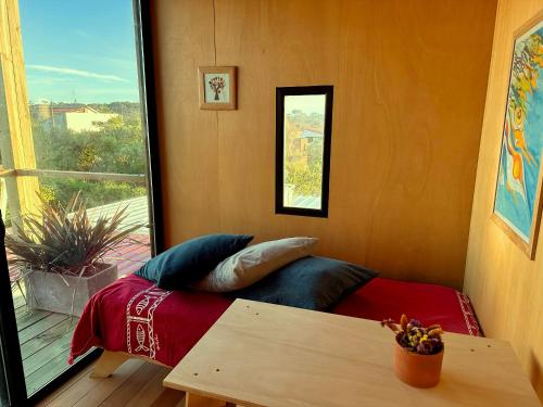 a bed in a room with a window and a table at CABITO B & B in La Paloma