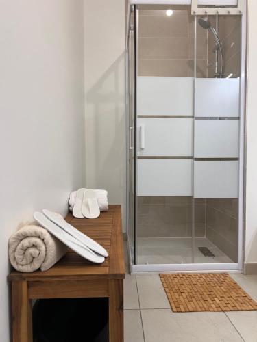 La salle de bains est pourvue d'une douche en verre et d'une table en bois. dans l'établissement L'appartement du golf- terrasse et jardin privé, à Bussy-Saint-Georges