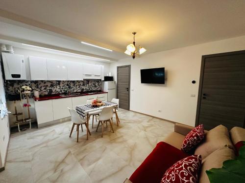 a kitchen and living room with a table and chairs at La Casa Rossa in Ca' di David