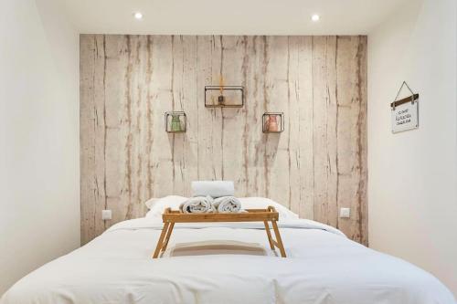 un lit dans une chambre avec un mur en bois dans l'établissement Symphony - Olympe Suites & Spa Lille, Tourcoing, à Tourcoing