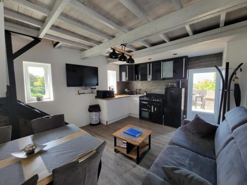 un salon avec un canapé et une table dans l'établissement Omonville-La-Rogue - La Grange, à Omonville-la-Rogue