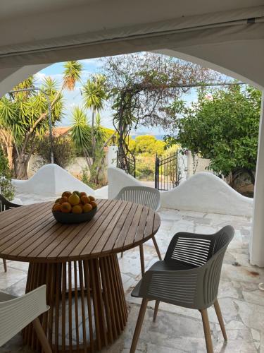 a wooden table with a bowl of fruit on a patio at Wunderschönes Haus mit Meerblick in Isthmia