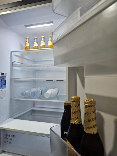 two bottles of beer in an open refrigerator at Estia Seaview Apartment in Golem