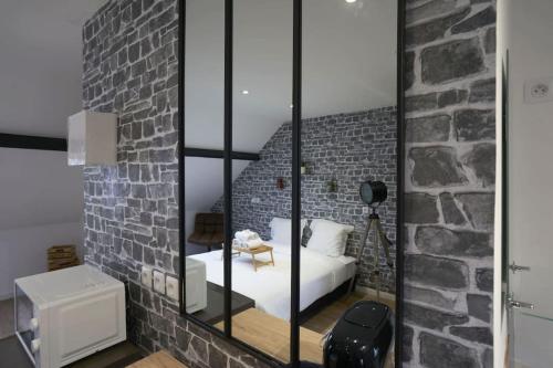 une chambre avec un lit et un mur de briques dans l'établissement NY Mood - Olympe Suites & Spa - Lille, Tourcoing, à Tourcoing