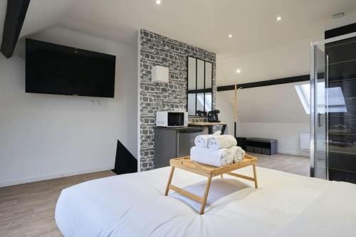 une chambre avec un grand lit blanc et une télévision dans l'établissement NY Mood - Olympe Suites & Spa - Lille, Tourcoing, à Tourcoing