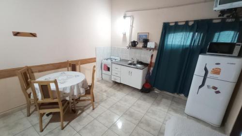 a small kitchen with a table and a refrigerator at Departamentos Paisaje del Beagle in Ushuaia