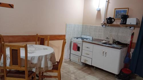 a kitchen with a table and a stove and a table and a table at Departamentos Paisaje del Beagle in Ushuaia