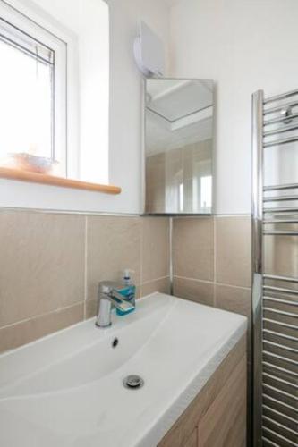 a white kitchen with a sink and a refrigerator at Bright Double Room l Smart TV l 5 Minute Walk from Train Station in Egerton