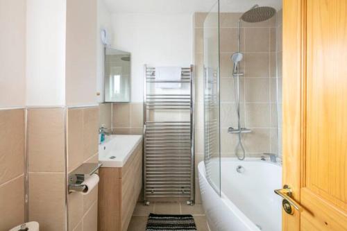 a bathroom with a tub and a toilet and a sink at Bright Double Room l Smart TV l 5 Minute Walk from Train Station in Egerton