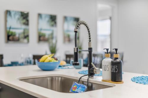 a kitchen counter with a sink with two bottles of wine at Delray Oasis - Private Pool - Fenced Yard - Parking - Laundry - Full Kitchen - Convenient Location in Delray Beach