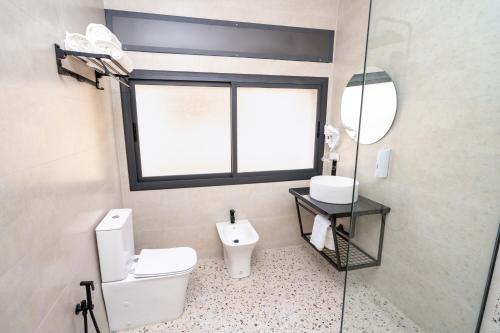 a bathroom with a toilet and a sink and a window at serenity stays-luxury suites & appart 2 in Tangier