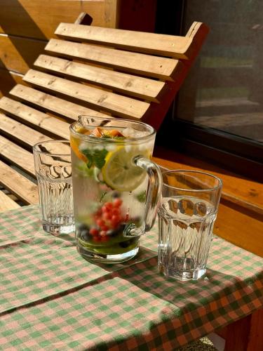 a glass pitcher of vegetables on a table with two glasses at Nad Strumykiem in Koszele