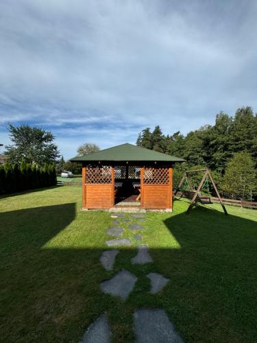 a gazebo in the middle of a grass field at Nad Strumykiem in Koszele
