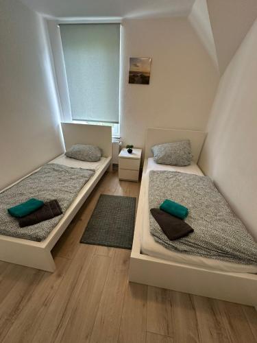 two beds in a room with two rugs at Modernes Apartment in Ruhiger Lage in nähe des Fischereihafens in Bremerhaven