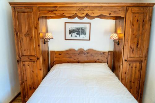 - un lit avec un cadre en bois dans une chambre dans l'établissement Résidence Les Hauts De Preclaux - Appartement 6 couchages au coeur des Orres 1800 MAE-4011, aux Orres
