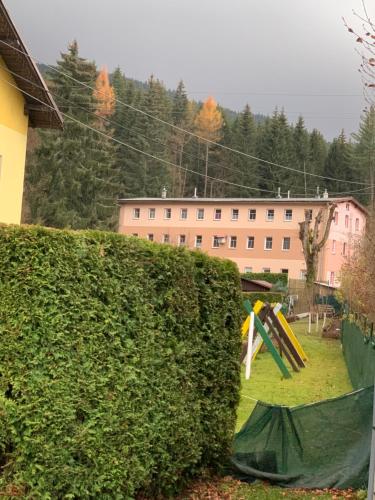 a hedge with a playground in front of a building at Apartment FOX in Kořenov