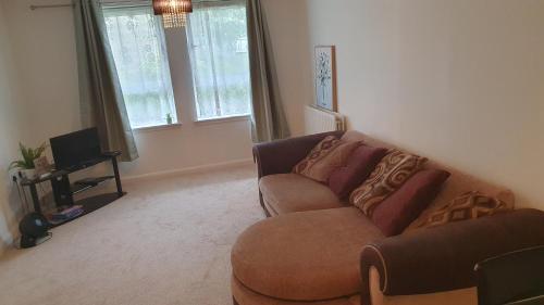 a living room with a couch and a tv at 2-bedroom Back Hilton Area apartment - Ground Floor, Aberdeen city center in Aberdeen