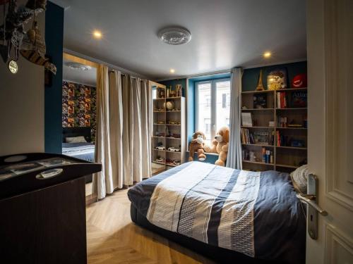 a bedroom with a bed and book shelves with stuffed animals at Duplex Jeanne d'Arc Billard Baby en option Escape Game Logements Insolites in Nancy