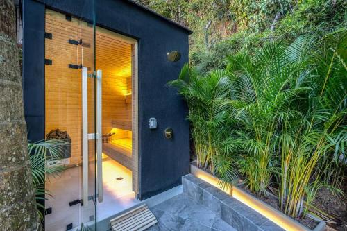 eine Pivot-Tür zu einem Haus mit Pflanzen in der Unterkunft Casa Luxe - Cold Plunge, Sauna, Pool, & Jacuzzi! in El Poblado