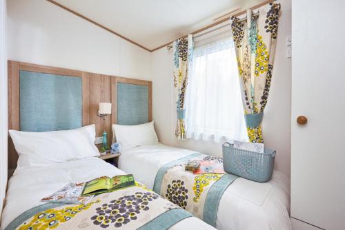 Giường trong phòng chung tại ABI Holiday Home - Brynteg Country & Leisure Retreat