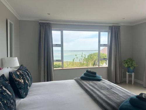 a bedroom with a bed with a large window at Lagoon Views at Langebaan in Langebaan