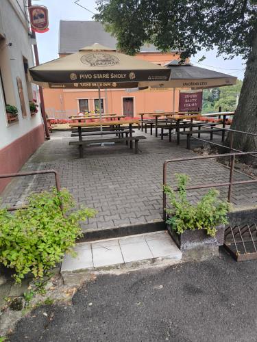 a group of picnic tables in front of a building at Penzion U Zeleného Stromu in Telnice