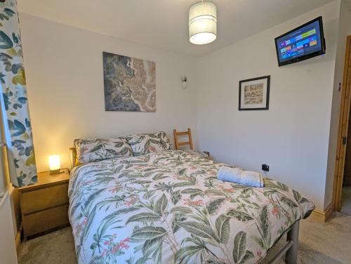 a bedroom with a bed and a tv on the wall at Bright Double Room l Smart TV l 5 Minute Walk from Train Station in Egerton