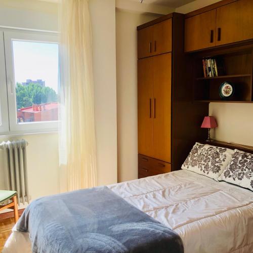 a bedroom with a bed and a window at Piso céntrico y luminoso in León