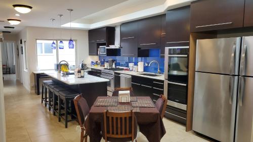 Il dispose d'une grande cuisine avec une table et un réfrigérateur. dans l'établissement Cozy SF Home 4 Bedroom 2 Bath, à San Francisco