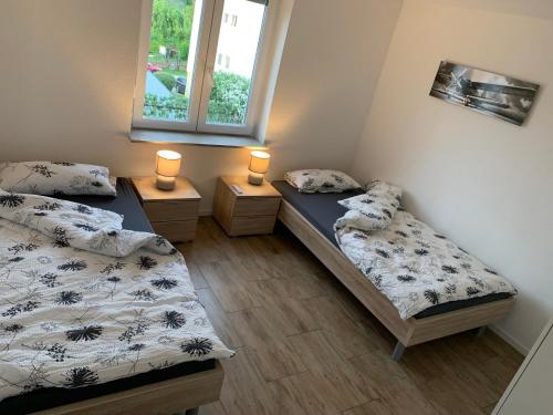 two beds in a room with two lamps on them at Klimatisierte Ferienwohnung in Balingen