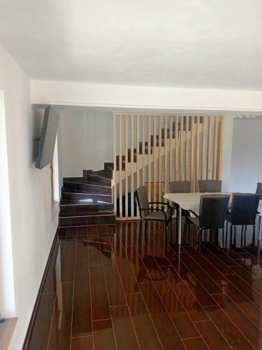 a dining room with a table and chairs and stairs at Cabana de închiriat la Colibița Straciorul in Colibiţa