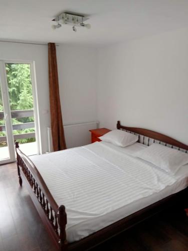 a large bed in a bedroom with a window at Cabana de închiriat la Colibița Straciorul in Colibiţa
