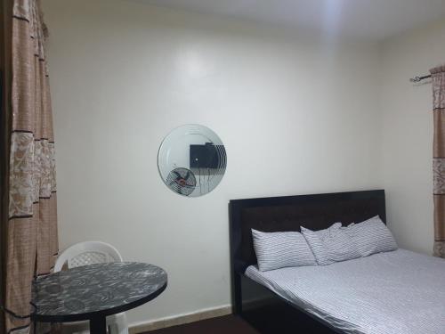 a bedroom with a bed and a mirror and a stool at Jowey Homestay in Abuja