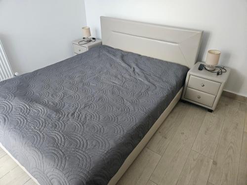 a small bedroom with a bed and two night stands at Apartament Andreea 15 in Mamaia Nord